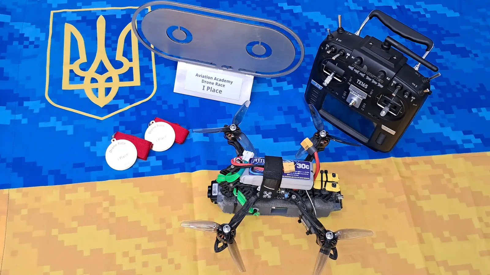 Дрон, пульт керування, кубок і медалі Robotex