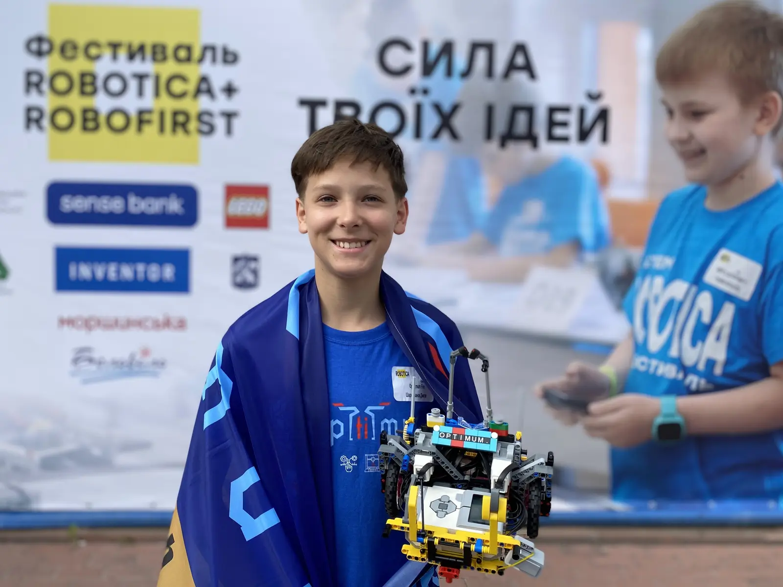 Учасник Optimum із автономним роботом і прапором клубу